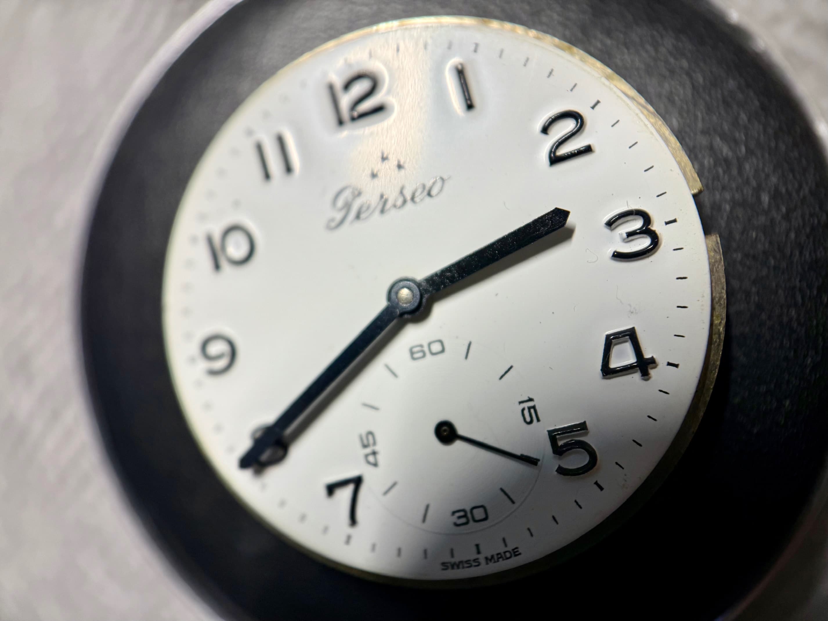 The Perseo dial with white enamel dial, black Arabic numerals, and sub-seconds at 6 o'clock